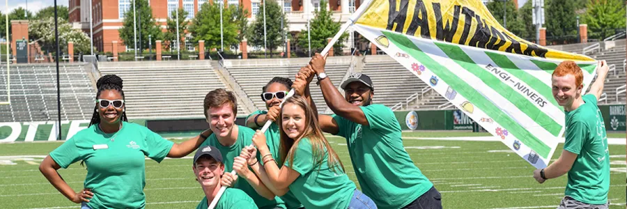 Students holding a green, yellow, and white Hawthorn Engi-Niners flage
