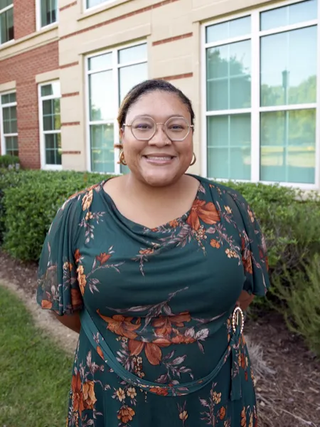 Maya Ryan smiling in front of a residence hall