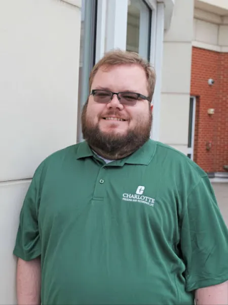 James Braman smiling outside in a green polo