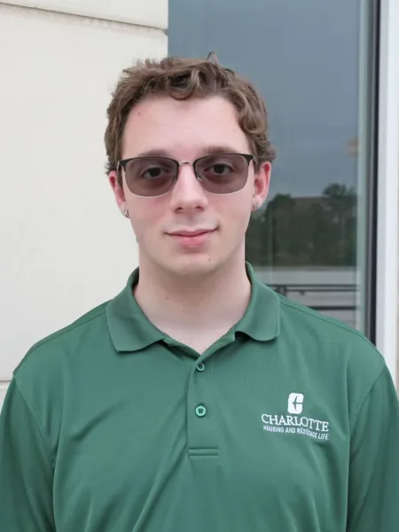 Marc Cammarata smiling outside in sunglasses and a green polo