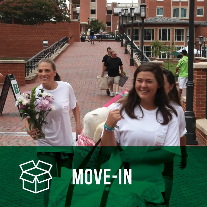 Image of 3 people moving bags and decorations into a residence hall