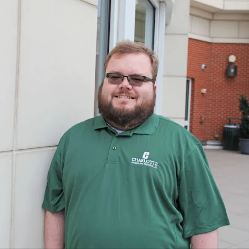 James Braman smiling outside in a green polo