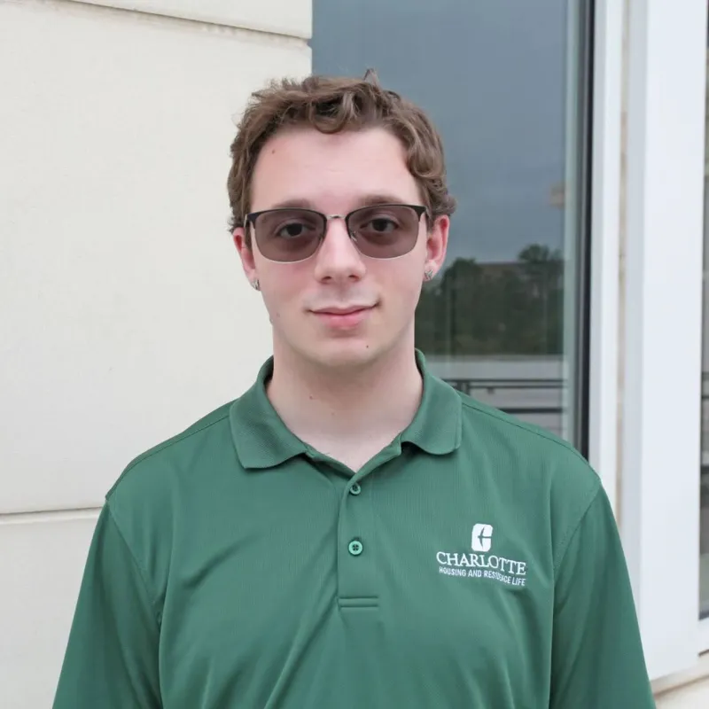 Marc Cammarata smiling outside in sunglasses and a green polo