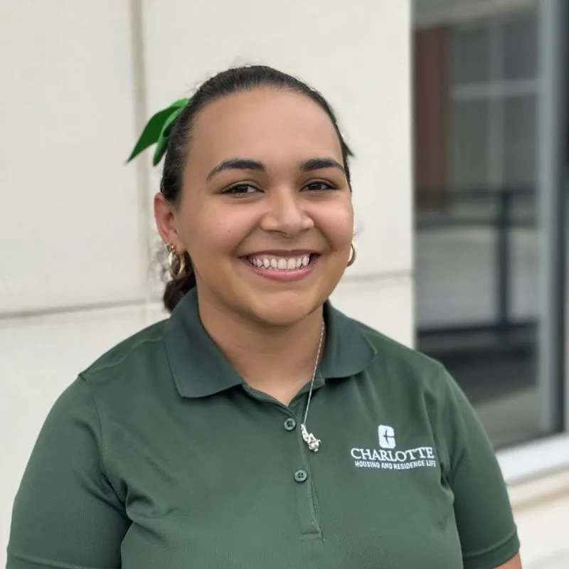 Chelsea Sisk smiling outside with a green polo